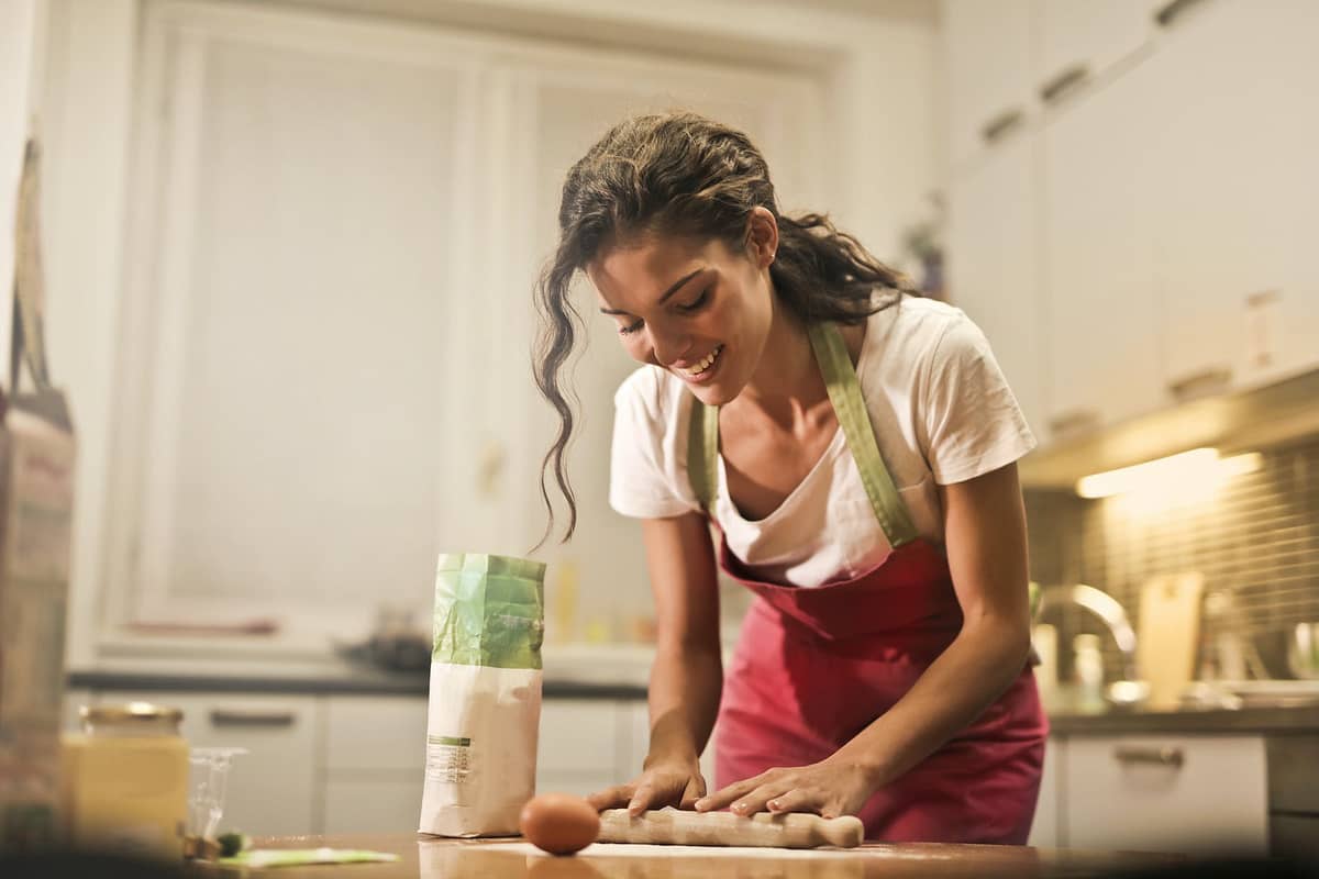 Household employees with rolling pin cooking at home